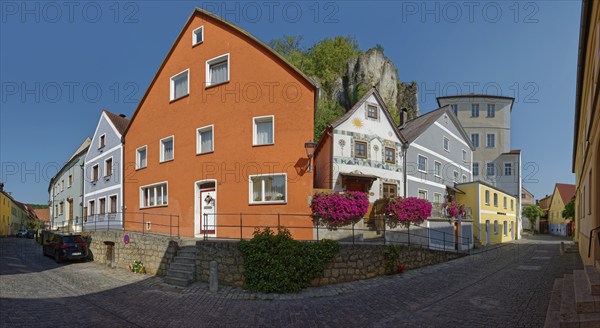 Colourful house front on Vils Gasse with a clear rock face in the background, Kallmünz, Upper