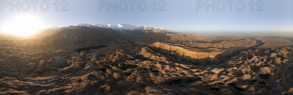 Panorama, White glaciated and snow-covered mountain peak Pik Lenin at sunrise, hilly landscape with