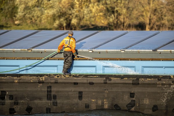 Sailor cleaning a cargo ship on the Rhine near Xanten, Lower Rhine, North Rhine-Westphalia,