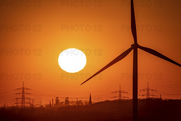 Wind turbine of the Emschergenossenschaft, view to the west, in Essen, sunset, behind the blast