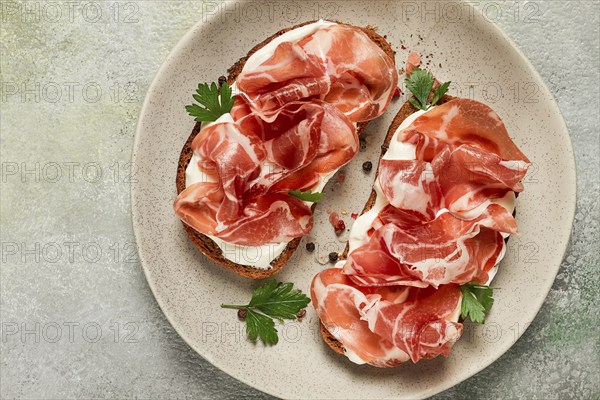 Sandwich with cream cheese and prosciutto, on black grain bread, breakfast, homemade