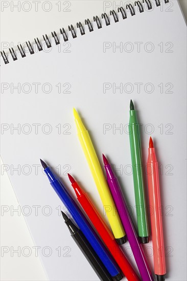 Watercolor pens brush, assortment, on a drawing album, artist's desk, top view, close-up, selective