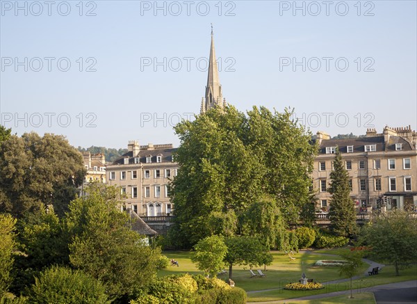 Parade Gardens public park in city centre of Bath, Somerset, England with church spire in