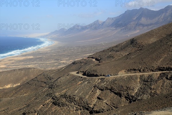 Car driving on unsurfaced road, Atlantic Ocean coast, Jandia peninsula, Fuerteventura, Canary
