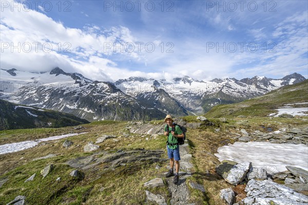 Mountaineer on hiking trail in picturesque mountain landscape, mountain peak with snow and glacier