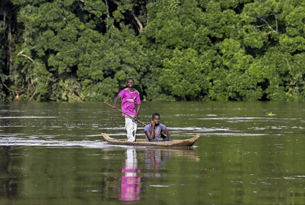 Two young men in a dugout canoe on the Sangha River, Dzanga-Sangha Complex of Protected Areas