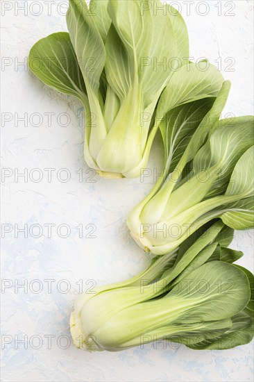 Fresh green bok choy or pac choi chinese cabbage on a white concrete background. Top view, close