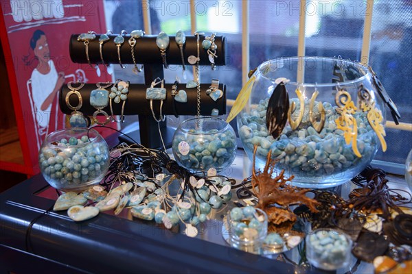 Various pieces of jewellery in aqua tones presented in glass jars on a sales table, sale of