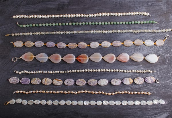 Set of semiprecious stone beads on a black background, top view