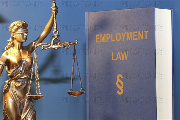 Symbolic image: Reference book Employment law (labour law) and a Justitia