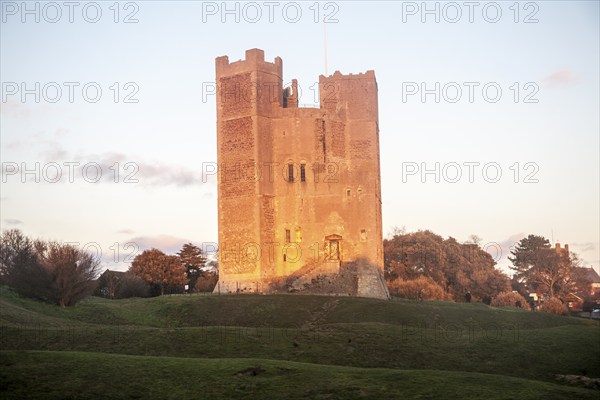 Late afternoon winter sunshine shining on walls of Orford Castle, Orford, Suffolk, England, United