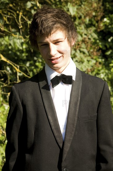 Model released portrait of young man wearing bow tie and suit jacket dressed for his school prom,