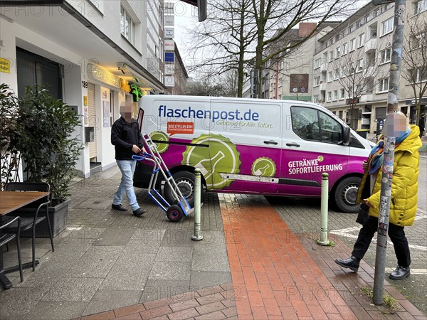 Delivery vehicle of the delivery service Flaschenpost.de parks on a pavement during delivery,