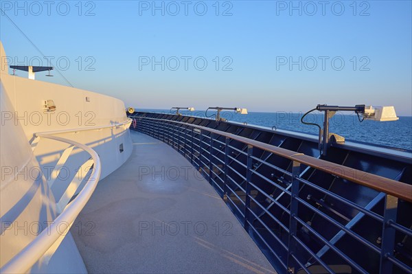 Deck of a cruise ship with clear blue sky and blue railing, Mein Schiff 6, North Sea, Denmark,