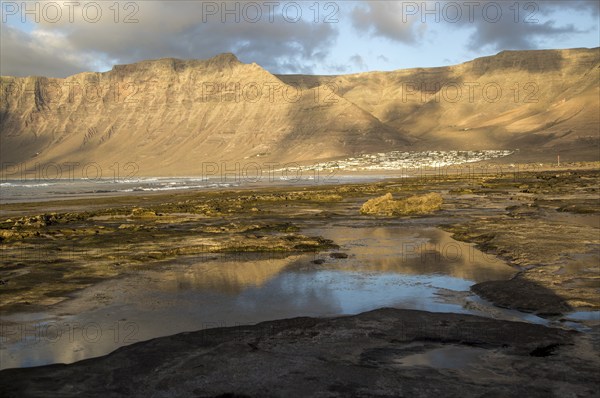 Late afternoon light on beach and cliffs La Caleta de Famara, Lanzarote, Canary islands, Spain,