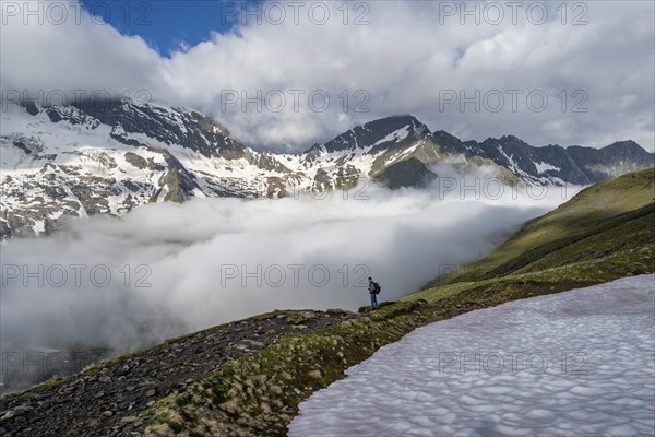 Mountaineer in front of mountain landscape with high fog in the valley, summit Hochfeiler and