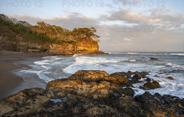 Sandy beach beach with rocks and sea at sunset, Playa Cocalito, coastal landscape, Pacific coast,