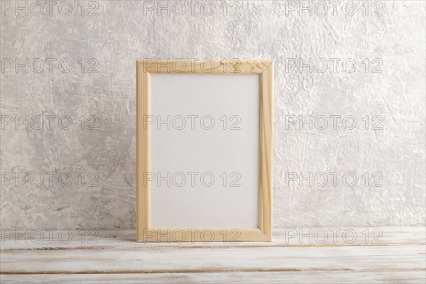White wooden frame mockup on gray concrete background. Blank, vertical orientation, still life,