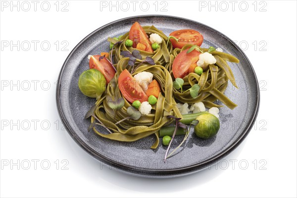 Tagliatelle green spinach pasta with tomato, pea and microgreen sprouts isolated on white