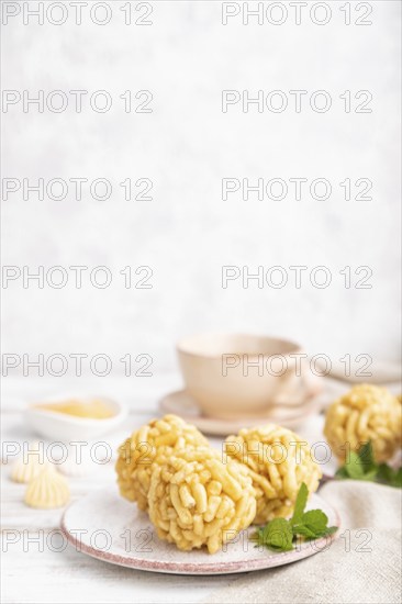Traditional Tatar candy chak-chak made of dough and honey with cup of coffee on a white wooden