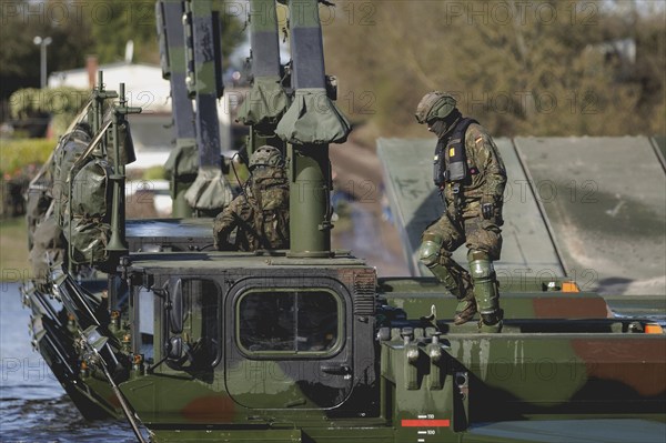 An engineer soldier stands on an amphibious vehicle of the type Amphibie M3 of the Bundeswehr,