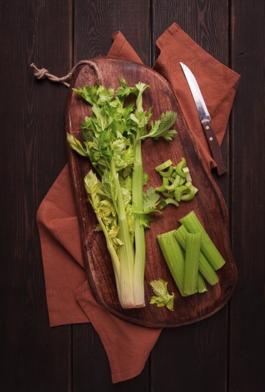 Fresh bunch of celery, top view, no people, on a dark background