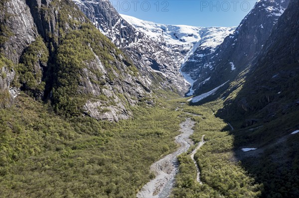 Aerial view of valley and gravel mountain road to glacier Kjenndalsbreen, valley Lodalen south of