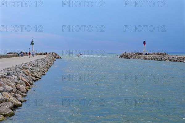 View of the sea through a narrow passage with lighthouses and rocks under a clear sky, summer, Le