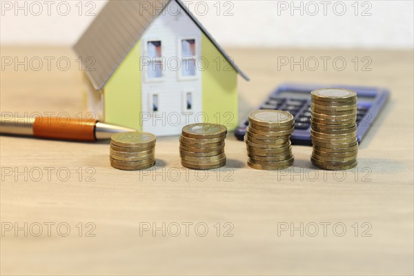 Concept photo with model house and coins