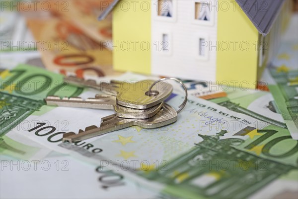 Concept photo with model house, euro notes and coins