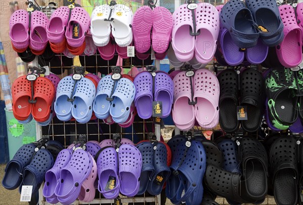 Display of colourful children's plastic Croc beach footwear at the seaside town of Cromer, north