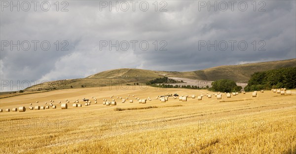 Round straw bales in a harvested arable field on the chalk scarp slope of the Marlborough Downs,