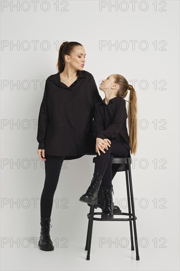 A modern family relations. Mother and daughter blowing an air kiss to each other