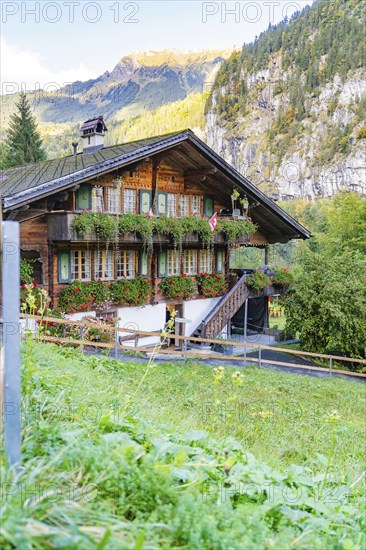 Cosy chalet with lush flowers, traditional Swiss architecture, nestled in a picturesque mountain