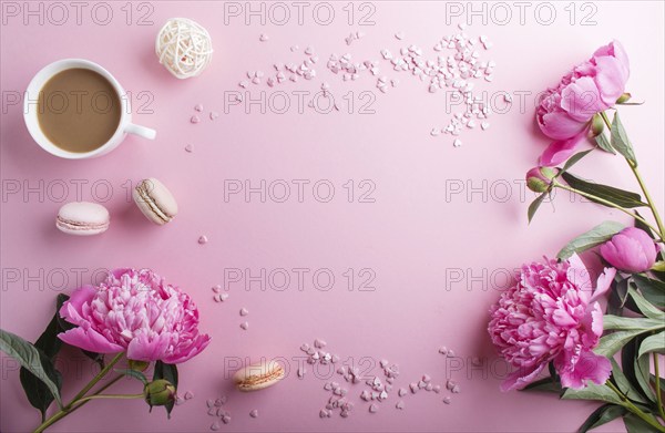 Pink peony flowers and a cup of coffee on a pink pastel background. Morninig, spring, fashion