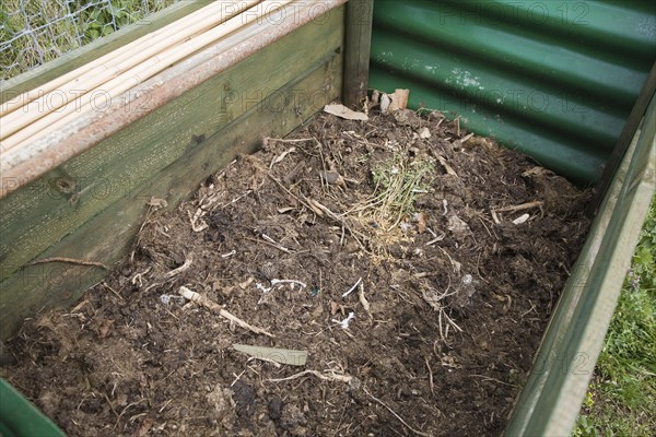 Rotted compost in garden composting bin
