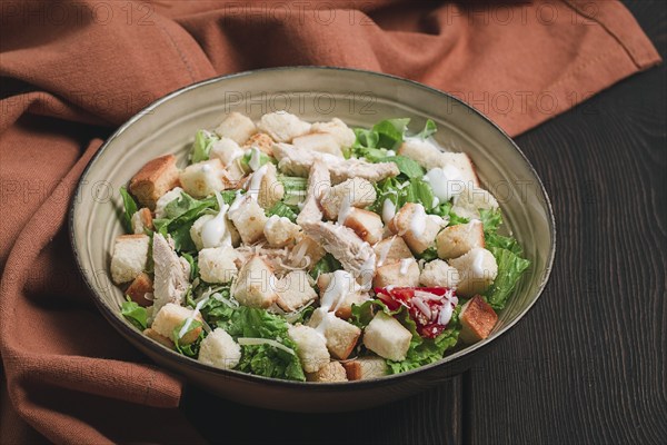 Fresh traditional Caesar salad, with chicken, on a wooden background, Top view, toned, horizontal