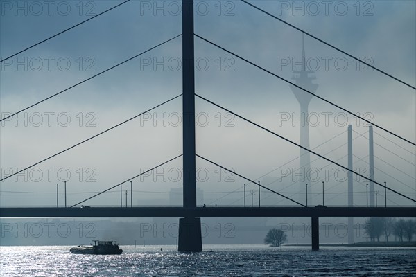 Dense fog slowly lifting, cargo ships on the Rhine near Düsseldorf, in front the Oberkassler