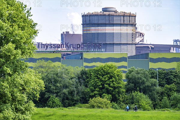 The ThyssenKrupp Steel steelworks in Duisburg-Beeckerwerth, cyclists on the Rhine dyke, green Rhine