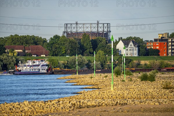 Cargo ship at low water on the Rhine near Duisburg-Homberg, view of Duisburg-Laar, houses on