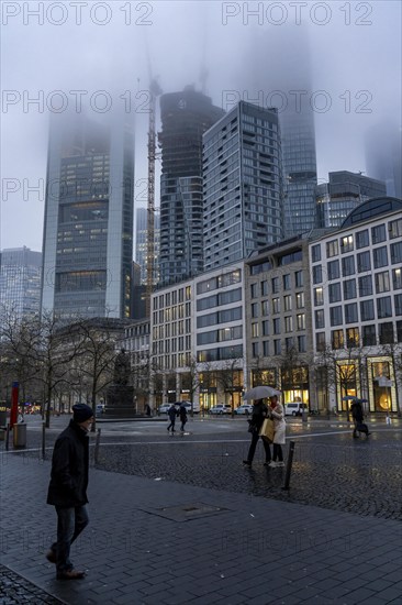 Rainy weather, freezing rain, Goetheplatz, high-rise skyline in clouds, passers-by hurrying through
