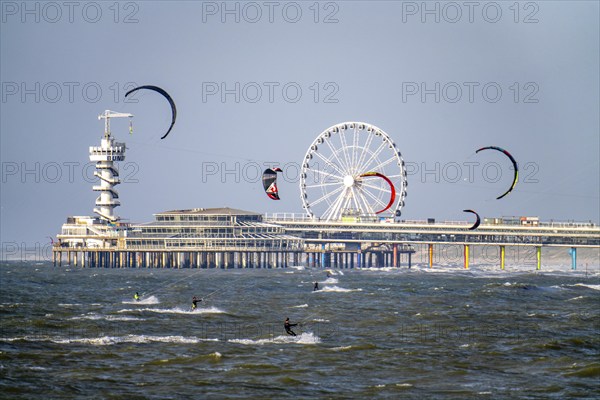 The pier and Ferris wheel at Scheveningen beach, strong swell, windsurfers, kitesurfers,