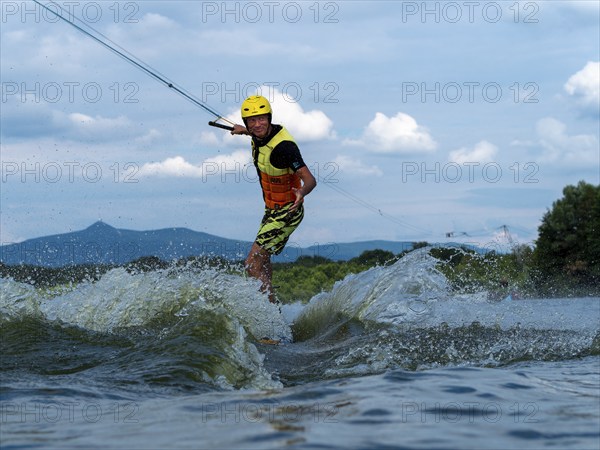 Man jumping with wakeboard, water sports, water skiing and wakepark