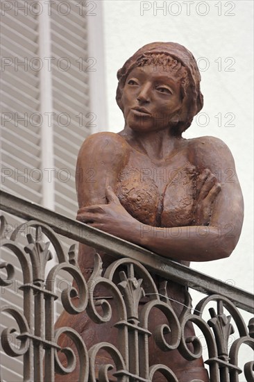 Sculpture by Nicole Brousse, brown woman on balcony railing, brown, standing, balcony railing,