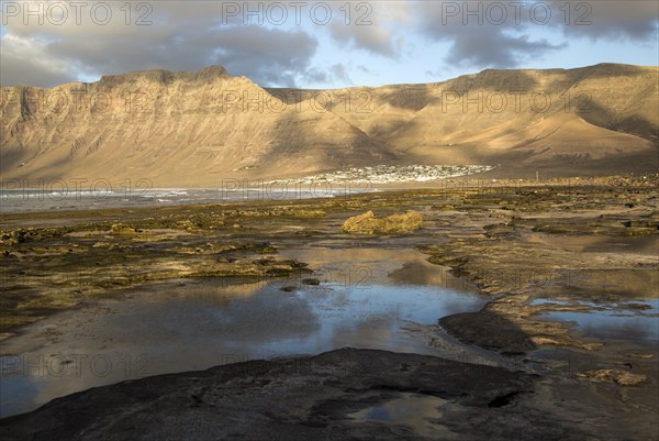 Late afternoon light on beach and cliffs La Caleta de Famara, Lanzarote, Canary islands, Spain,