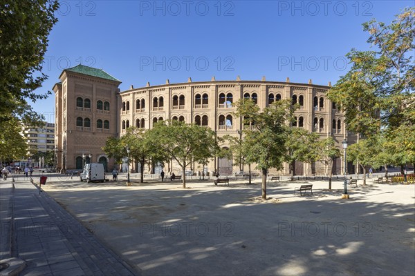 Brick bullring in a sunny setting with trees and clear skies, Granada