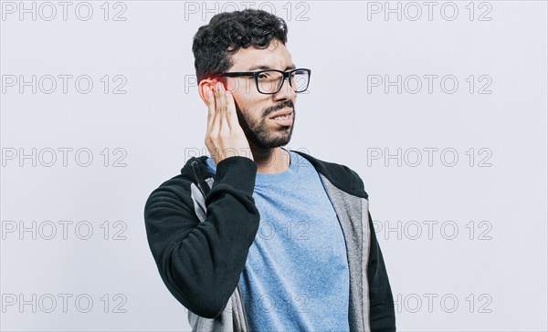 Person with ear pain, on isolated background, Suffering man massaging his ear isolated, concept of