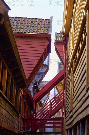 Narrow alley between old half-timbered houses with stairs, dominating wooden architecture in red