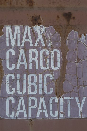 Close-up of maximum cargo cubic weight holding capacity indicated on outside of shipping container,