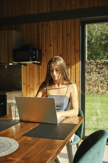Woman looking for a recipe in internet sitting at the kitchen table
